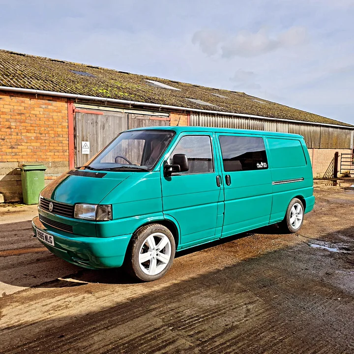 Volkswagen T4 Transporter with alloy wheels photographed from the front quarter outside the workshop.