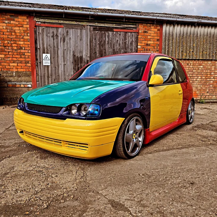 Multicolour car photographed outside the workshop.
