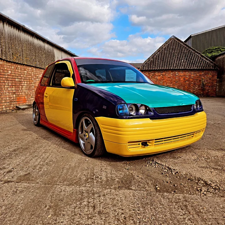 Multicolour car photographed outside the workshop.