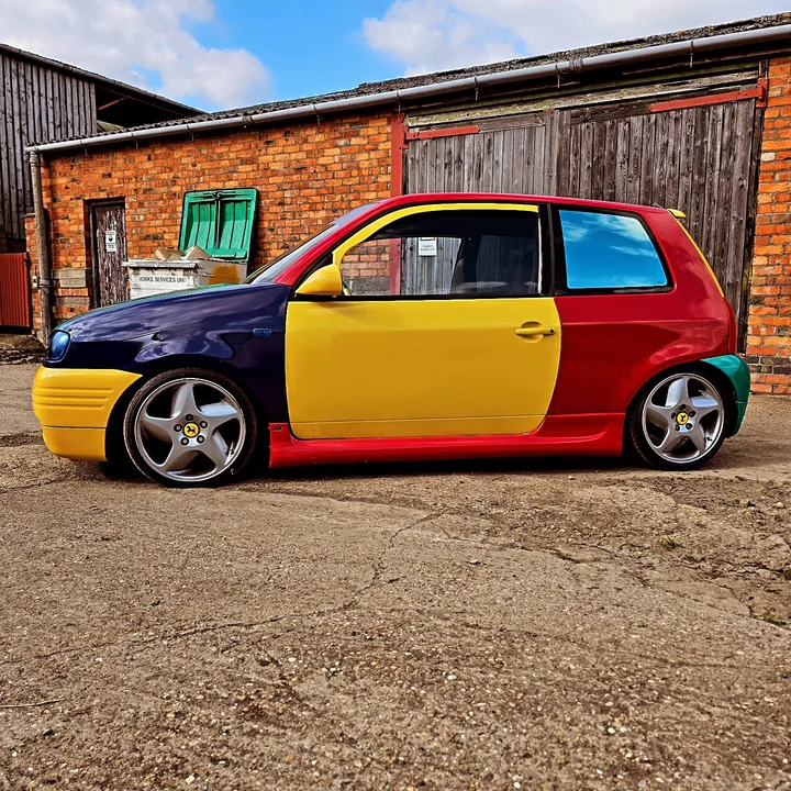Multicolour car photographed outside the workshop.