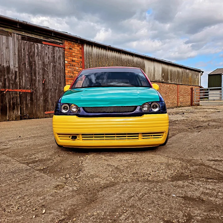 Multicolour car photographed outside the workshop.