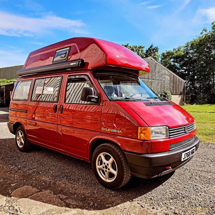 Volkswagen T4 California high-roof camper parked outside the workshop in sunshine.