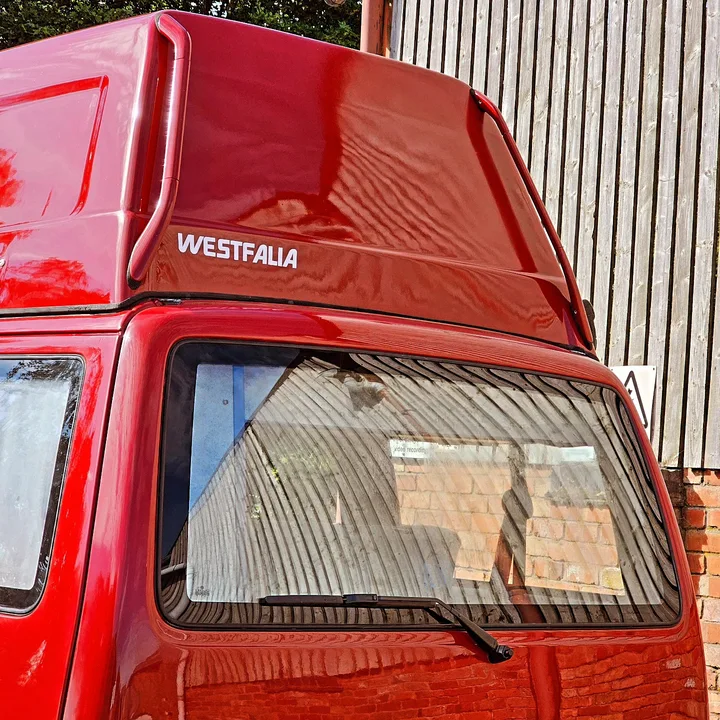 Close view of the glossy high roof and upper side window of a Volkswagen T4 California camper.