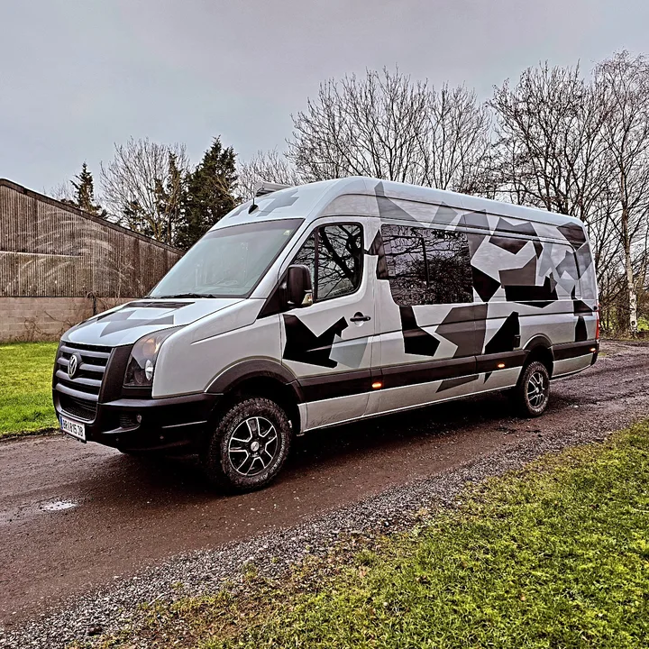 Front three-quarter view of a high-roof Crafter showing angular side graphics and dark side windows.