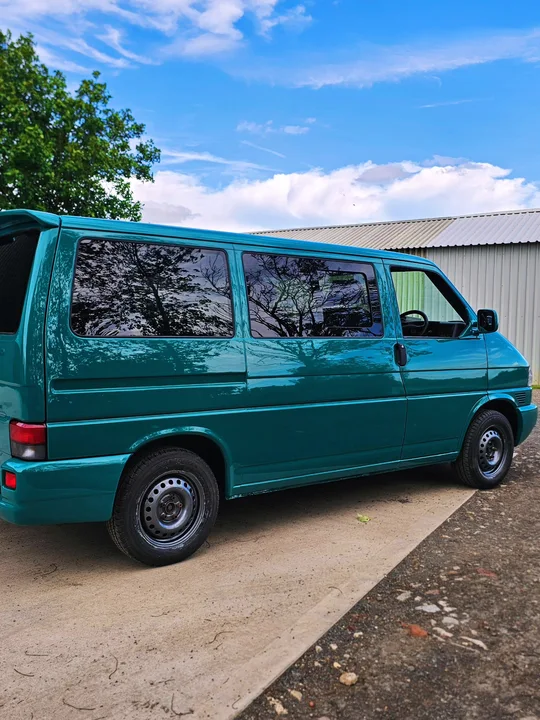 Teal T4 Transporter viewed along its side with dark windows and black wheels.