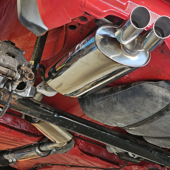 Red refinished underside with polished exhaust, fuel tank and rear suspension visible